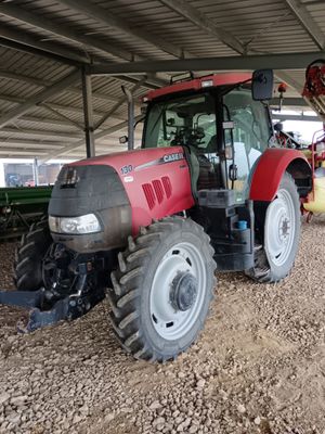 un tracteur rouge garé sur la terre battue