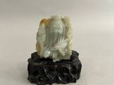 une image représentant une statue d'une personne assise sur un rocher