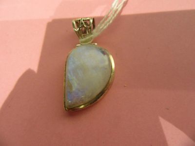 une photo d'un pendentif orné d'une pierre bleue