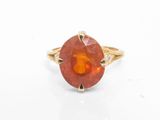 Gros plan sur une bague contenant une pierre orange