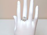 a white hand with a ring on it that has a diamond on it