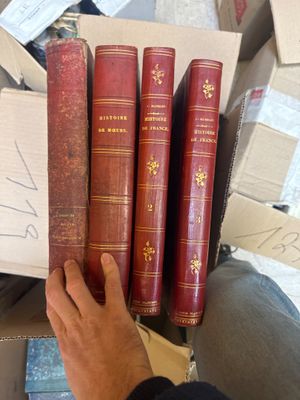 un homme qui tient une pile de livres