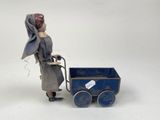 a doll that is standing next to a toy stroller