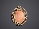 a yellow gold pendant with a pink stone in the center