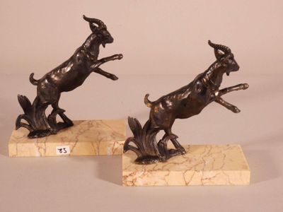 pair of bronze statues of a goat and a dog on marble bases