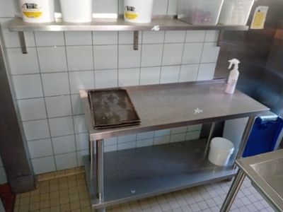 a kitchen with a sink, stove, and shelves in it