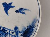 a blue and white plate with birds and flowers on it