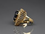 a close up of a gold ring with a black stone in it