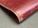 red leather wallet on a gray surface with a black background