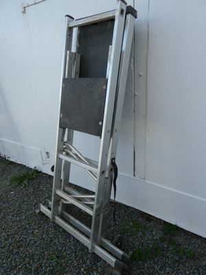 a ladder leaning against a white wall with a chair on it