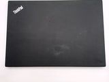a black laptop on a white surface with a sticker on it