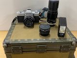 a camera, a camera case, and a cell phone on a table