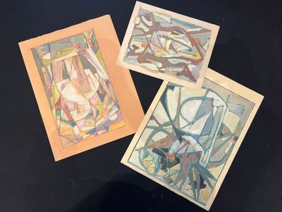 three paintings of different shapes and sizes on a black surface