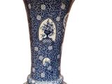 a blue and white vase sitting on a white surface