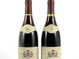deux bouteilles de vin posées l'une à côté de l'autre sur une surface blanche