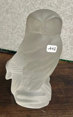 un hibou en verre posé sur une table en bois