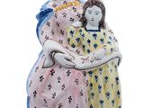 une figurine représentant une femme tenant un enfant dans ses bras