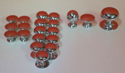 beaucoup de boutons rouges et argentés posés sur une table blanche