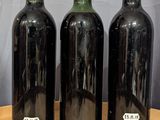 three bottles of wine sitting on a table next to each other