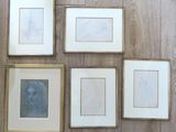 quatre photos encadrées représentant le visage d'une femme, posées sur un parquet