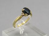 gros plan d'une bague en or avec une pierre noire
