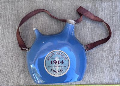 a blue jug with a brown strap and a measuring tape