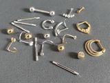 a lot of different types of ear piercings on a table