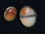 two pieces of brooches are sitting on a black surface