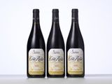three bottles of wine are lined up on a table