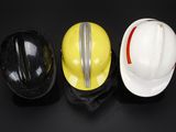 three hard hats sitting on top of each other on a black surface