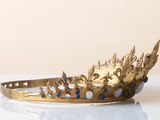 a gold crown with blue stones on it on a white table