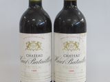two bottles of red wine sitting next to each other on a table