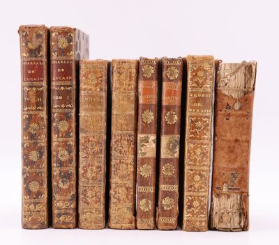 plusieurs vieux livres sont alignés sur une surface blanche