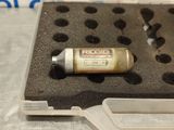 a small bottle of liquid sitting on top of a piece of foam