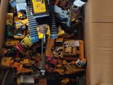 une boîte en carton remplie de petites voitures et de engins de chantier