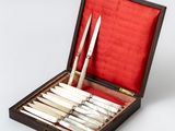 a wooden box with a set of knives and knives in it