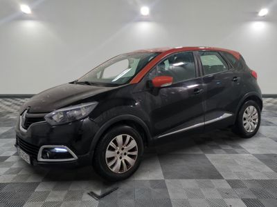 La voiture noire et rouge est garée sur un sol à damier.