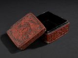 an old red box sitting on top of a black surface