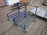 un chariot bleu posé par terre à côté d'une pile de palettes