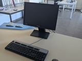 a computer monitor and keyboard on a desk in a room
