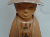 a small figurine of a boy with a hat on