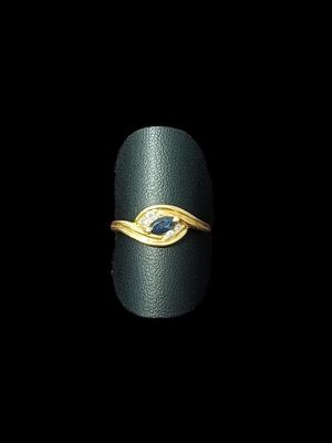 une image d'une bague en or avec une pierre bleue