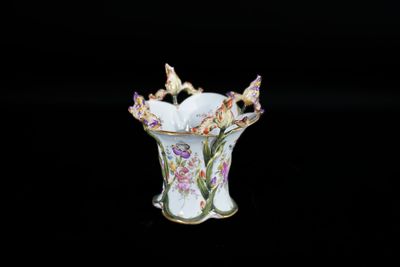 un petit vase contenant des fleurs, posé sur une surface noire