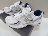 white new balance shoes with blue accents on top of a box