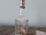 a glass bottle with a silver lid sitting on a table