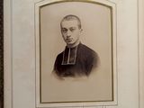 an old photo of a man in a priest ' s robes in a frame