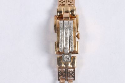 une image représentant une montre en or et en argent posée sur une surface blanche