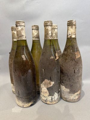 quatre bouteilles de vin vides sont alignées sur une table
