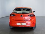 an orange car is parked in a white room with a black floor