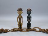 paire de figurines en bois représentant deux hommes et un chien sur une branche